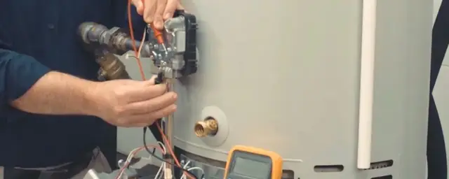 Technician testing the wiring on a tank water heater with a multimeter